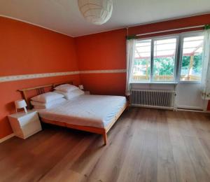 sypialnia z pomarańczowymi ścianami, łóżkiem i oknem w obiekcie Hus nära sjö och säfsenresort w mieście Fredriksberg
