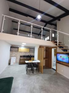 Cette grande chambre dispose d'une table à manger et d'une télévision. dans l'établissement LOFTS GREEN ISLAND, à Angra dos Reis