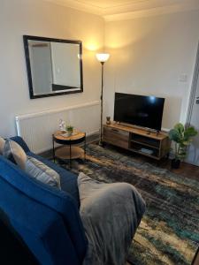 a living room with a blue couch and a flat screen tv at Dalston 1 bedroom flat in London