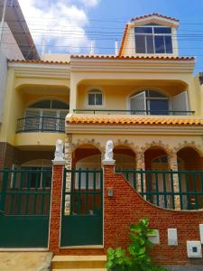 una casa con puertas verdes y ladrillo rojo en Excelente localización en Praia en Praia