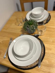 a wooden table with plates and utensils on it at Dalston 1 bedroom flat in London