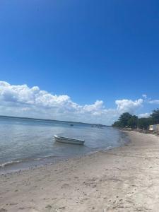 a boat sitting in the water on a beach at CASA Praia Cacha Pregos in Vera Cruz de Itaparica