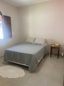 ein Schlafzimmer mit einem Bett in einem weißen Zimmer in der Unterkunft CASA Praia Cacha Pregos in Vera Cruz de Itaparica