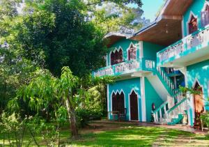 een blauw huis met een boom ervoor bij The Green Heaven Resort in Sigiriya