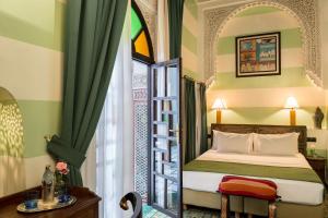 1 dormitorio con 1 cama junto a una ventana en Algilà Fes Riad Medina Charme Hotel, en Fez