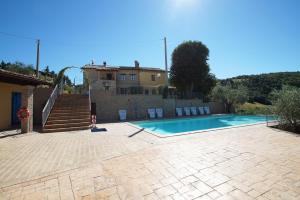 a swimming pool in front of a house at Agriturismo La Valle dei Fiori di Bellucci Rosanna in Torre deʼ Calzolari