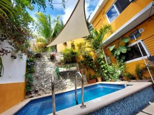 a swimming pool in front of a house at Estudio con terraza in Cozumel