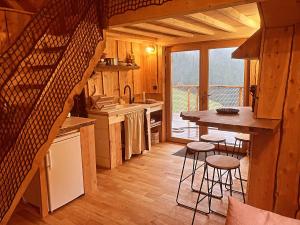 a kitchen with a table and stools in a cabin at Cabane Insolite de la Semine in La Pesse