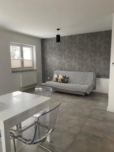 a living room with a bed and a table and chairs at Apartament Jana Pawła in Nowy Sącz