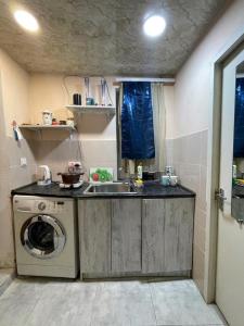 a kitchen with a sink and a washing machine at Babulya House in Gyumri