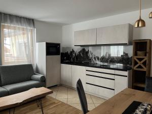 a kitchen with a couch and a table in a room at A Sosta in Selva di Val Gardena