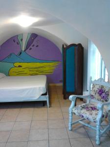 1 dormitorio con 1 cama y 1 silla en La Casetta, en Nápoles