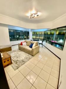 een woonkamer met een bank en een tafel bij Apartamento em Torres in Torres +11 foto's