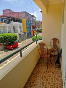 un balcón con mesa y sillas y un coche rojo en una calle en Excelente localización en Praia en Praia