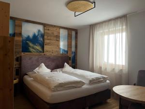 a bedroom with a bed with white pillows on it at A Sosta in Selva di Val Gardena