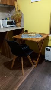 uma mesa de madeira com uma cadeira numa cozinha em Tinyhouse im Herzen von Varna em Varna City