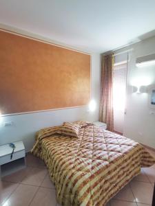 グロッセートにあるHotel Il Parcoのベッドルーム1室(大型ヘッドボード付きのベッド1台付)