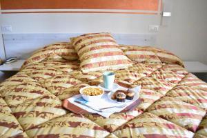 a bed with a tray of donuts and a tray of food at Hotel Il Parco in Grosseto