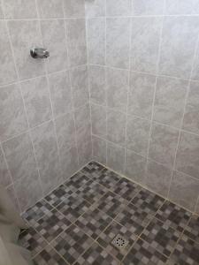 a shower stall with a tiled floor and a tile floor at Hostal El Amate #2 in Suchitoto
