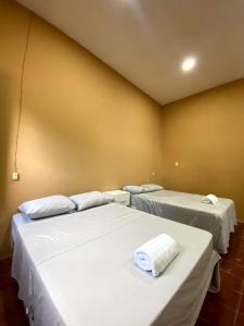 a room with two beds with white sheets at Hostal El Amate #2 in Suchitoto