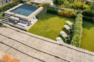 vista aerea su un cortile con piscina e sedie di OraBlu Executive Villas a Ischia