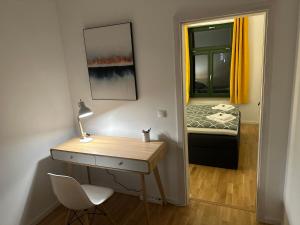 a room with a desk and a bedroom with a bed at Chez Amis Arena in Leipzig
