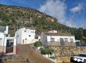 un coche blanco estacionado frente a una montaña en Casa Diego. Algodonales (Cadiz), en Algodonales