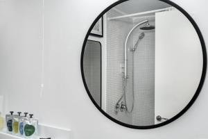 a mirror in a bathroom with a shower stall at the container house in Ra‘ananna