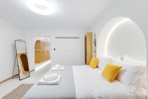 Habitación blanca con cama grande con almohadas amarillas. en Magpie's Nest Athens (3' απο το μετρό Άγιος Ιωάννης), en Atenas