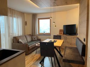 een woonkamer met een bank en een tafel bij A Sosta in Selva di Val Gardena