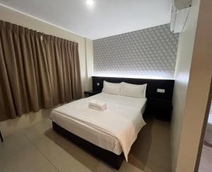 a bedroom with a large white bed in a room at Pekan Auto City Budget Hotel in Pekan