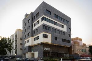 a tall gray building with cars parked in a parking lot at توجاردن النهضة - Tu jardin Al Nahda in Jeddah