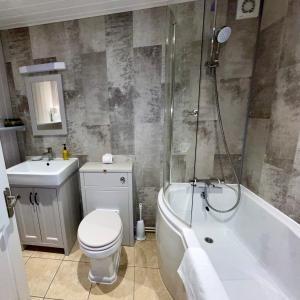 uma casa de banho com um WC, uma banheira e um lavatório. em Sibton White Horse Inn em Saxmundham
