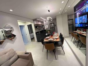 ein Esszimmer und ein Wohnzimmer mit einem Tisch und einem Sofa in der Unterkunft Apartamento Frente Mar Bc 704 in Balneário Camboriú