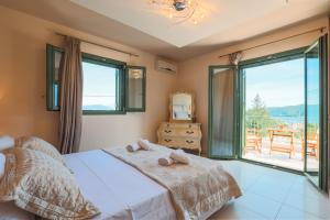 a bedroom with a bed and a large window at Scorpios Villa in Kefallonia +22 photos