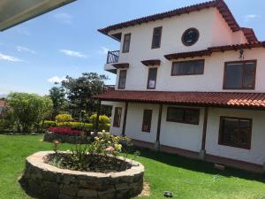 a house with a garden in the yard at Villa Lulu in Tibasosa