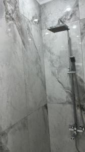 a bathroom with a shower with a glass door at Люкс Апартаменты в центре левого берега Астаны in Taldykolʼ +8 photos