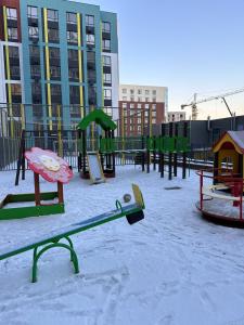 an empty playground in a city with snow on the ground at Люкс Апартаменты в центре левого берега Астаны in Taldykolʼ