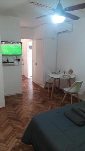 Habitación con cama, mesa y TV. en departamento en almagro, 2 huéspedes en Buenos Aires