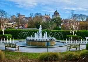 une fontaine dans un parc avec deux bancs dans l'établissement Queen Annes court luxury apartment on high street, à Windsor