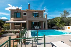 a villa with a swimming pool in front of a house at Scorpios Villa in Kefallonia