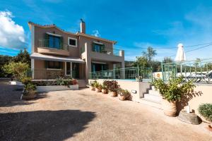 a house with a balcony and a patio at Scorpios Villa in Kefallonia