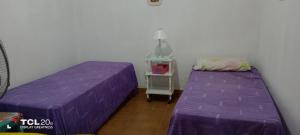 duas camas num quarto com lençóis roxos em Hospedaje LA LUCIA em Almafuerte