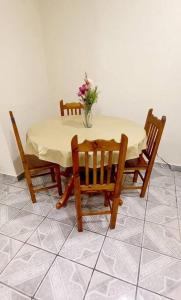 a table with four chairs and a vase with flowers on it at Casa Andrea. Crucecita Huatulco. in Santa Cruz Huatulco