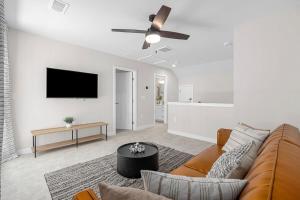 a living room with a couch and a flat screen tv at Upscale Townhome, Prime Location in North Myrtle Beach