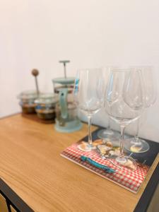 three wine glasses sitting on top of a wooden table at Cozy 33m2 2-room Studio Apartment in City Center in Rīga