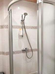 a shower with a shower head in a bathroom at Cozy 33m2 2-room Studio Apartment in City Center in Rīga