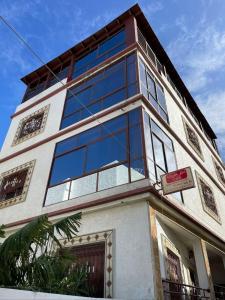 a building with a lot of windows on it at Appartements el hichou 2 in Ksar es Sghir