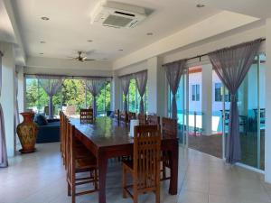 a dining room with a wooden table and chairs at Kamala Heights Villa in Kamala Beach