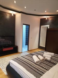 um quarto com uma cama grande e toalhas em NANA"S HOUSE APARTAMENT 2 Camere,2 bai em Sibiu